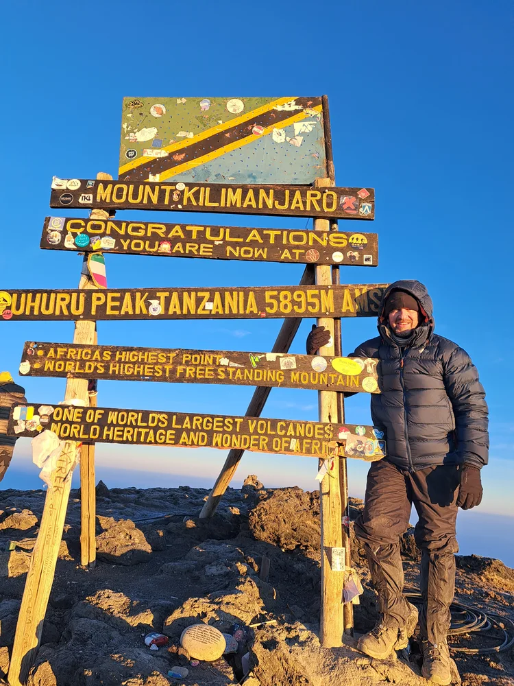 David Holloway beside the Kilimanjaro summit sign